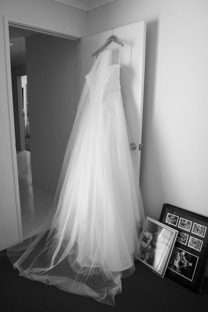 Wedding dress hanging on the back of a door