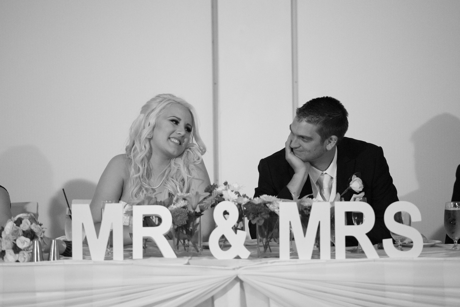 Bride and groom looking at each other at their reception table