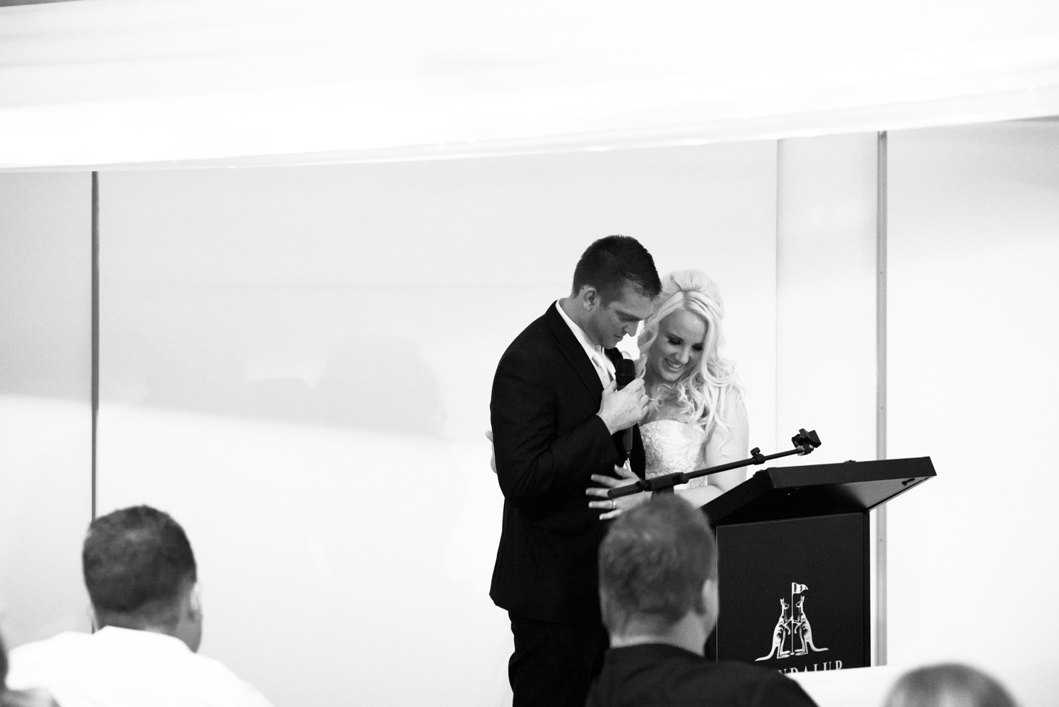 Bride with the groom during his speech