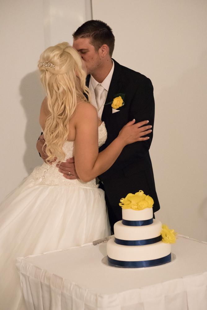 Bride and groom kissing after cutting the cake