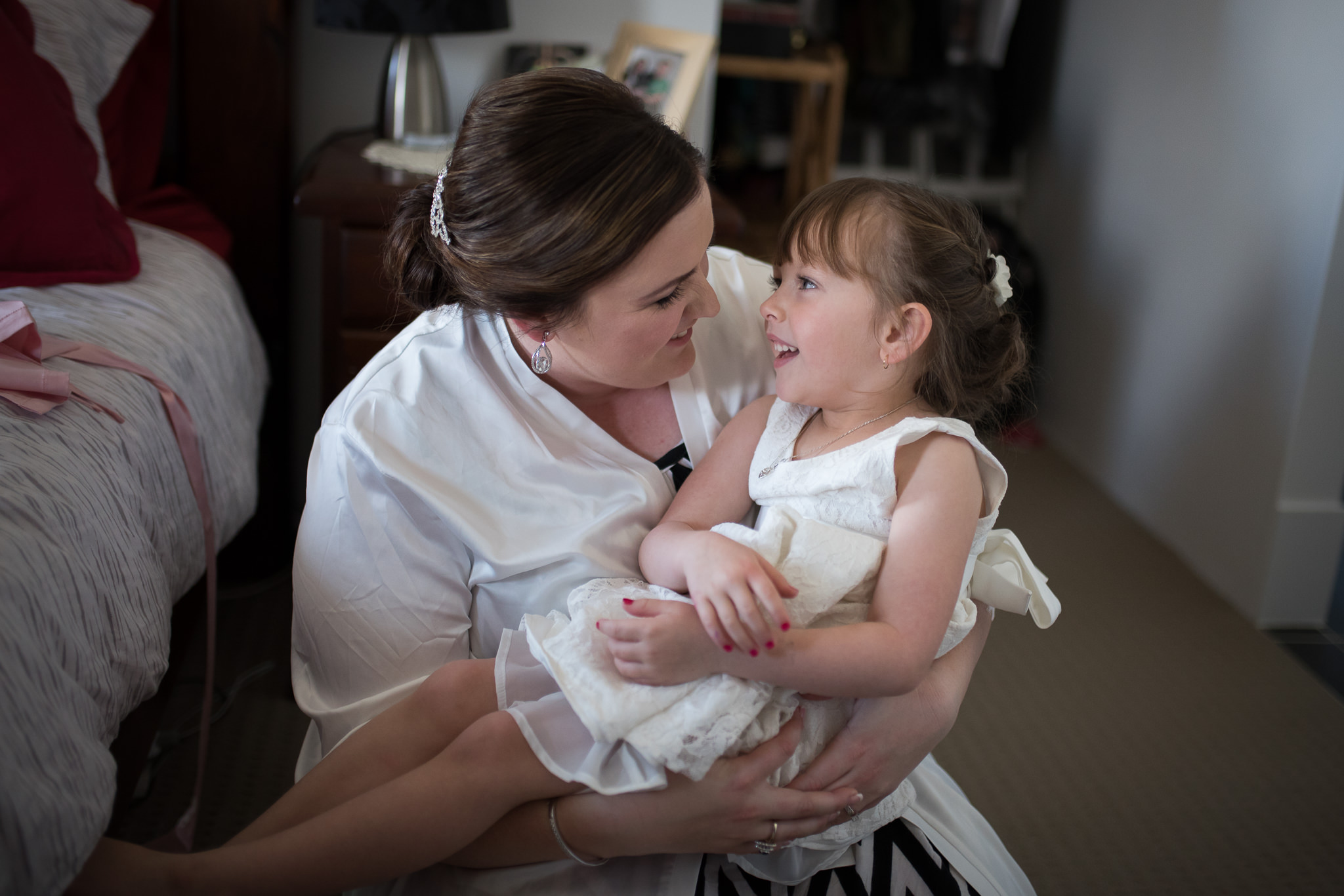 bride cuddles the flower girl getting ready