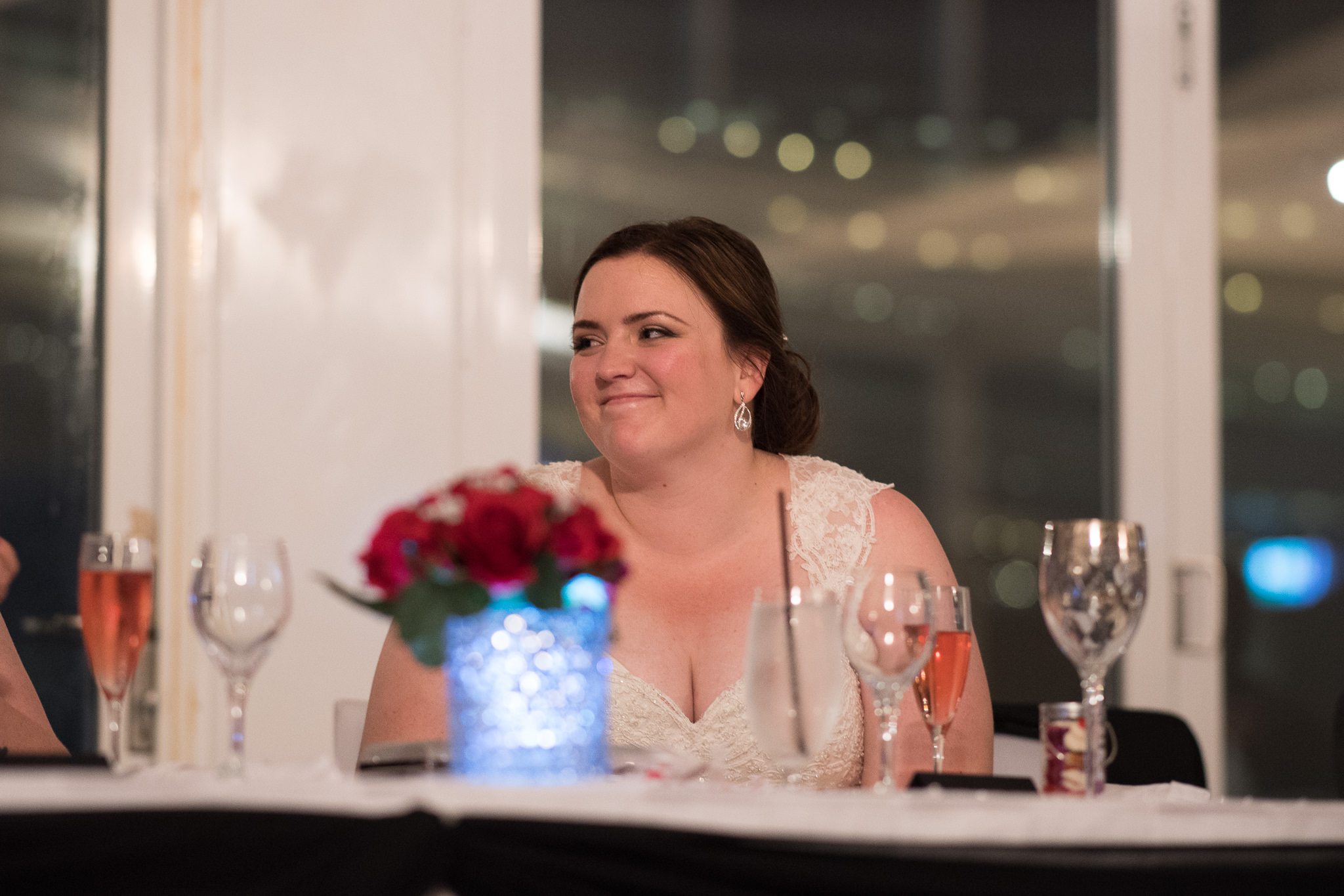 bride smiles at her groom during speeches