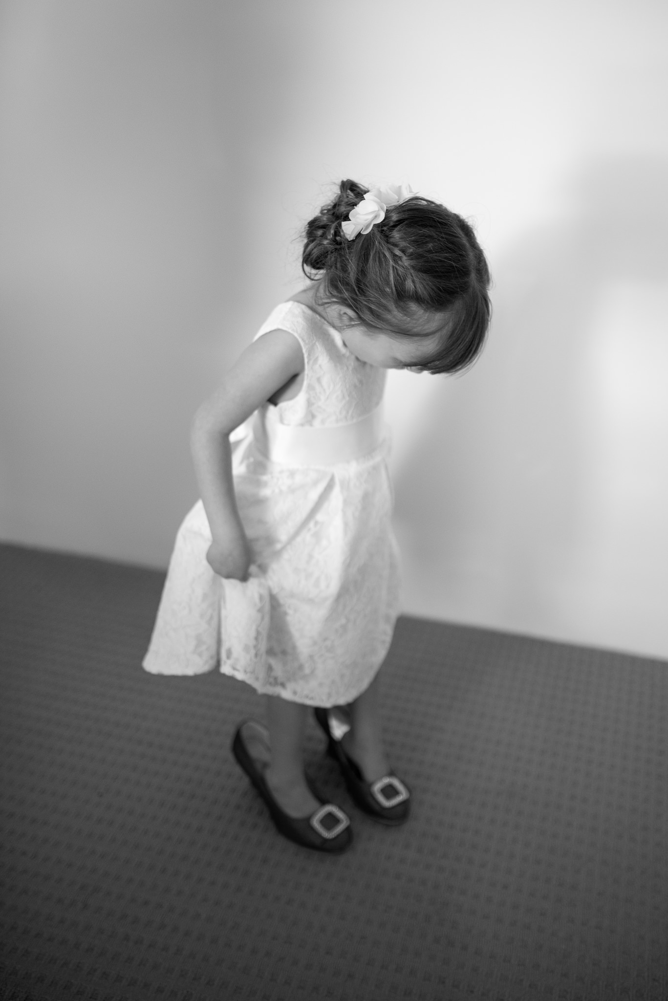 flower girl looks down at bride's wedding shoes on her feet