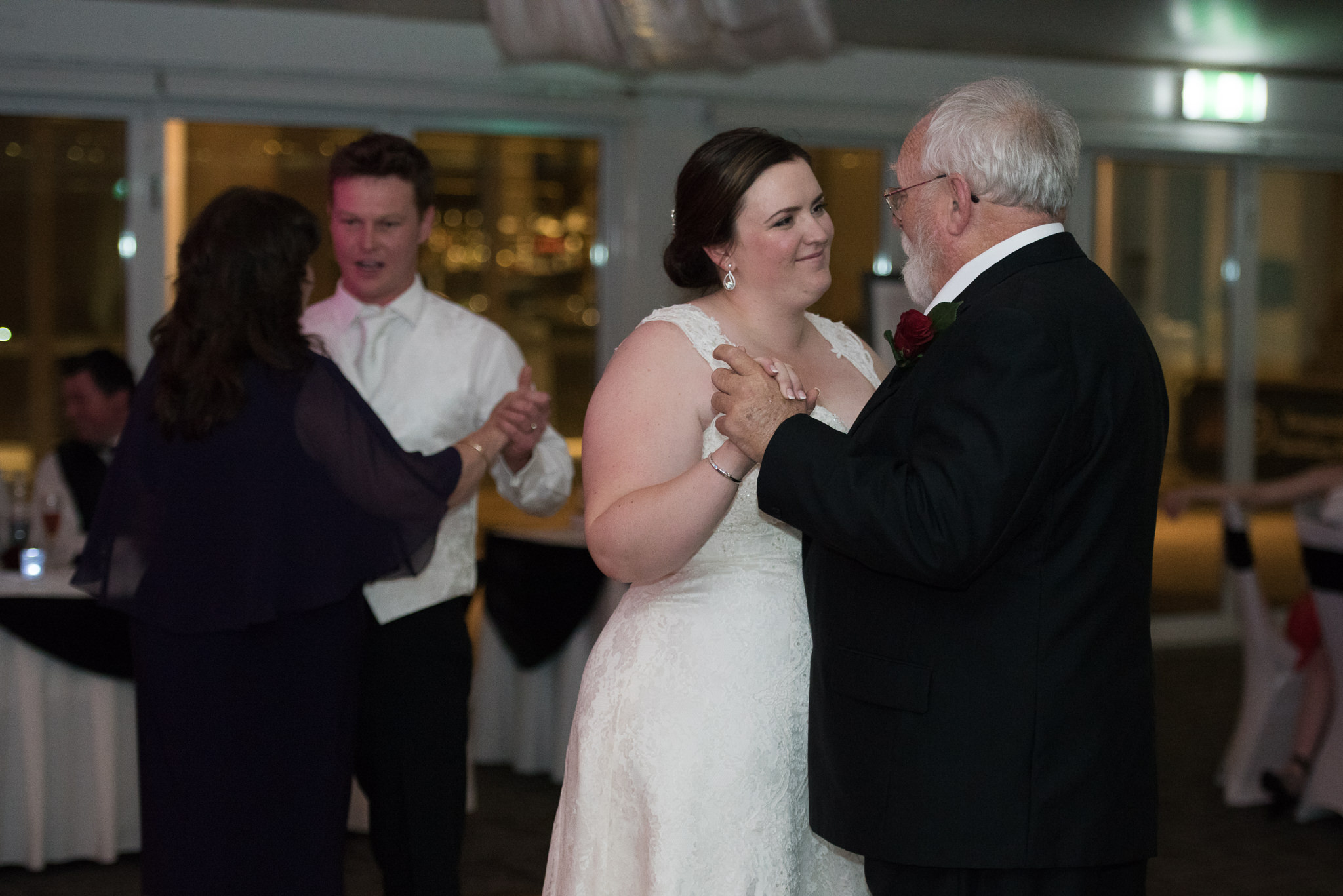 Bride and father dance with groom and mother