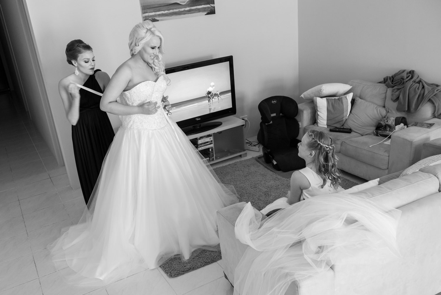 Bride having her wedding dress tied up