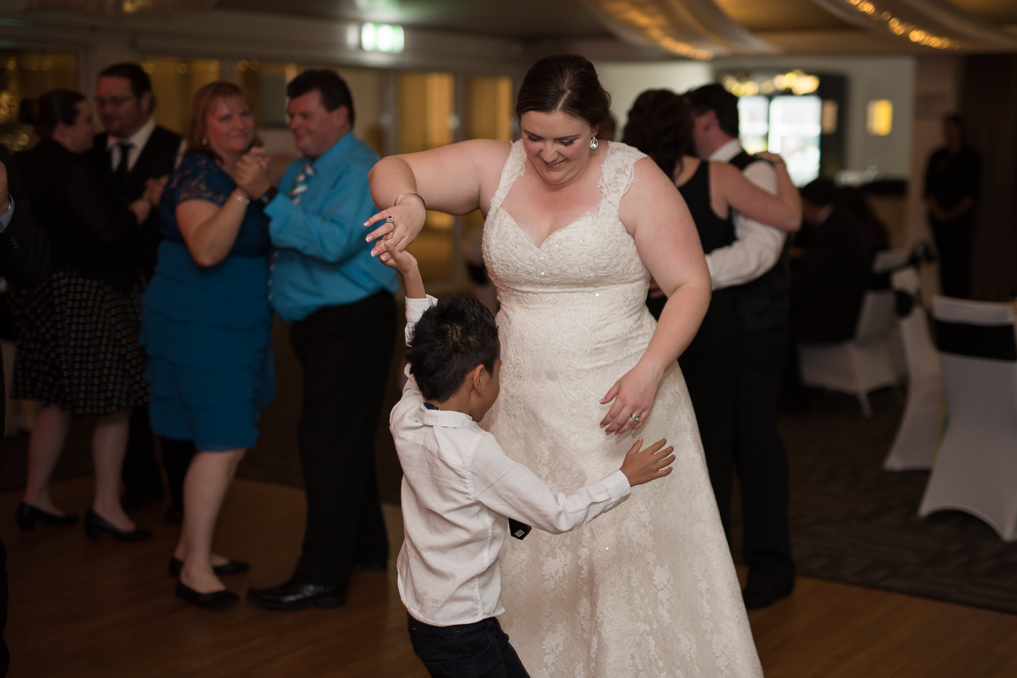 bride dancing with little boy at her reception