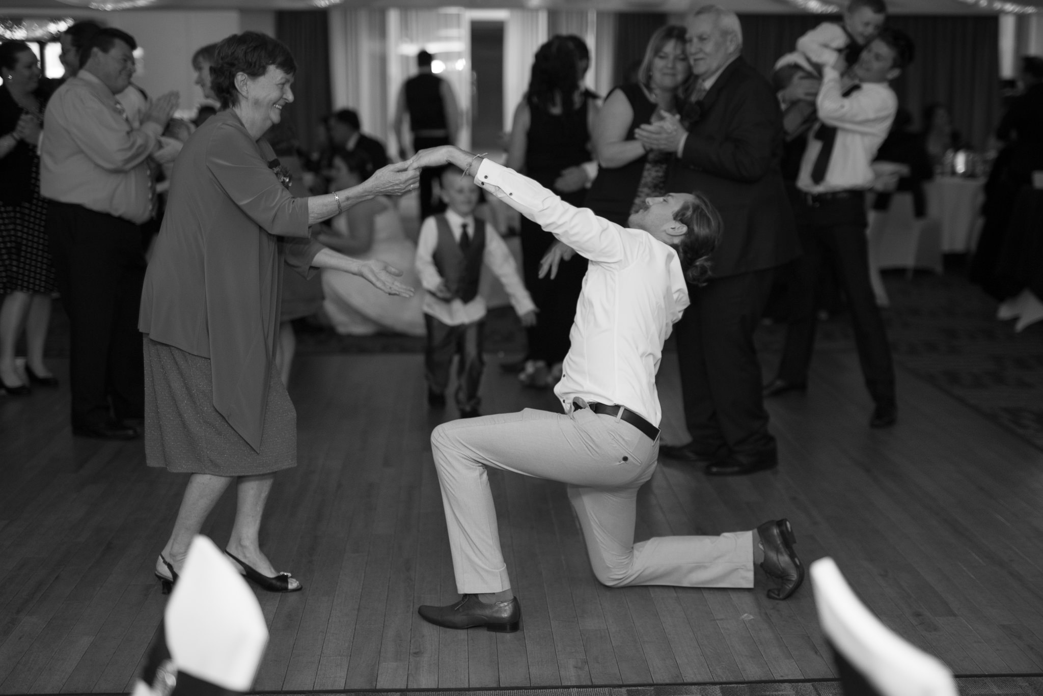 dramatic wedding guest on his knee on the dance floor