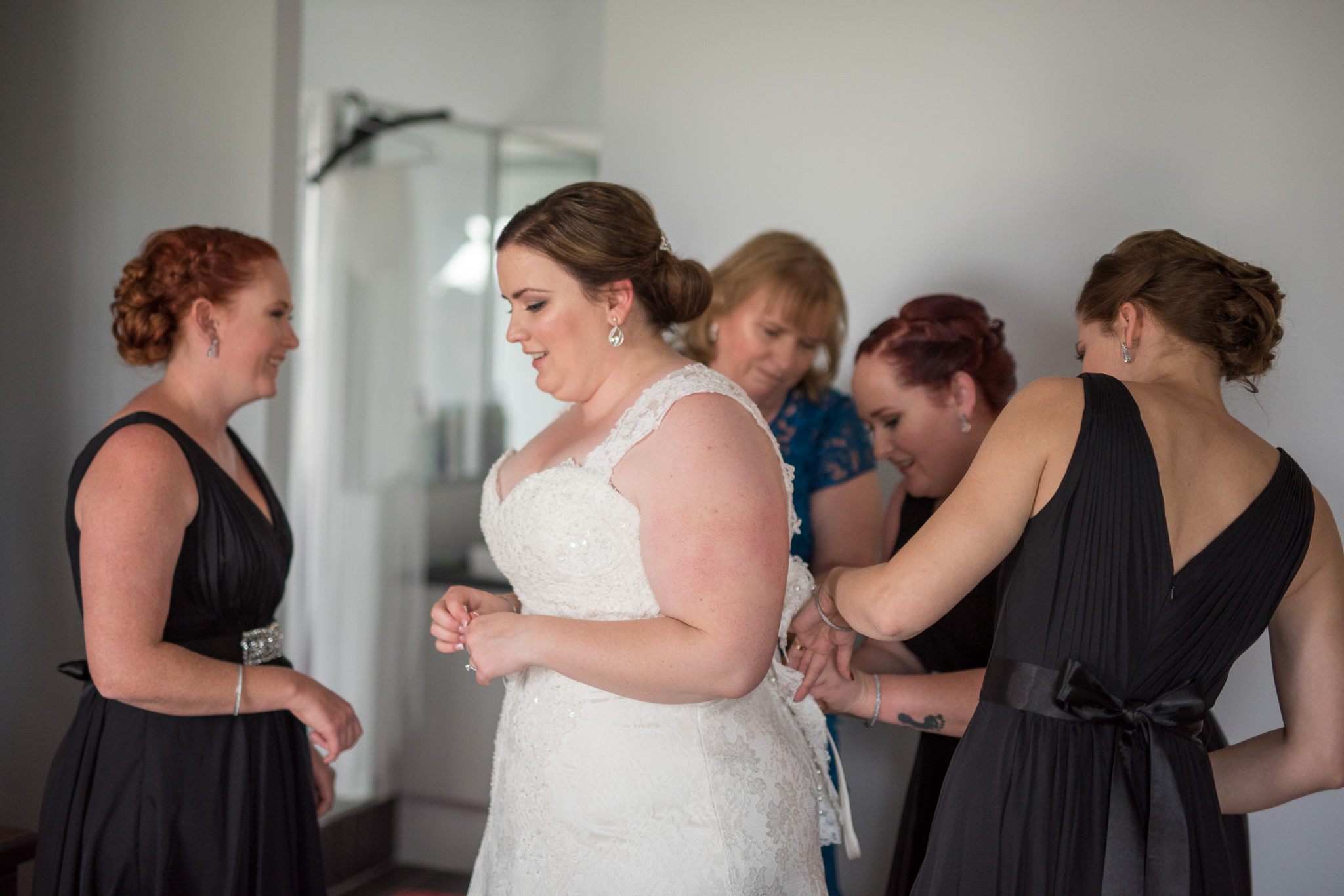 bride has her wedding dress buttoned up