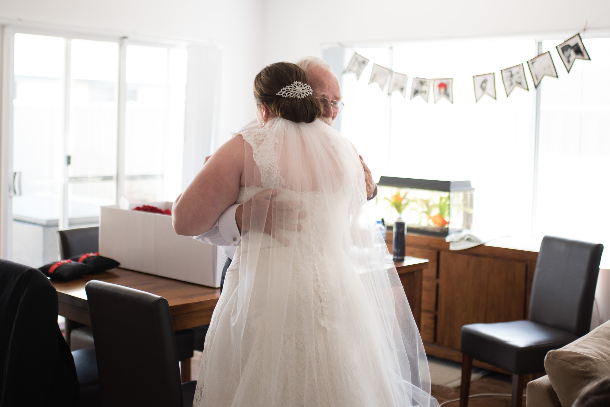 father hugs the bride when he sees her for first time