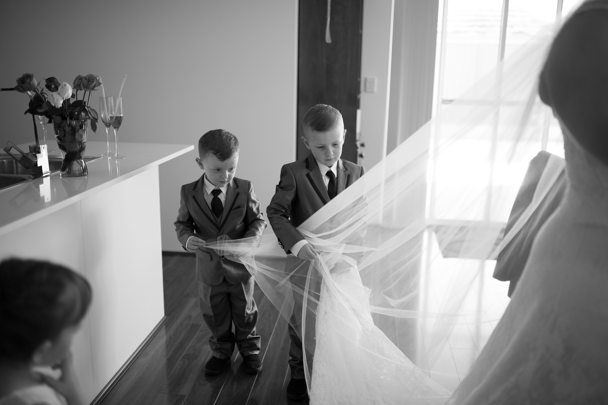 page boys play with the bride's veil