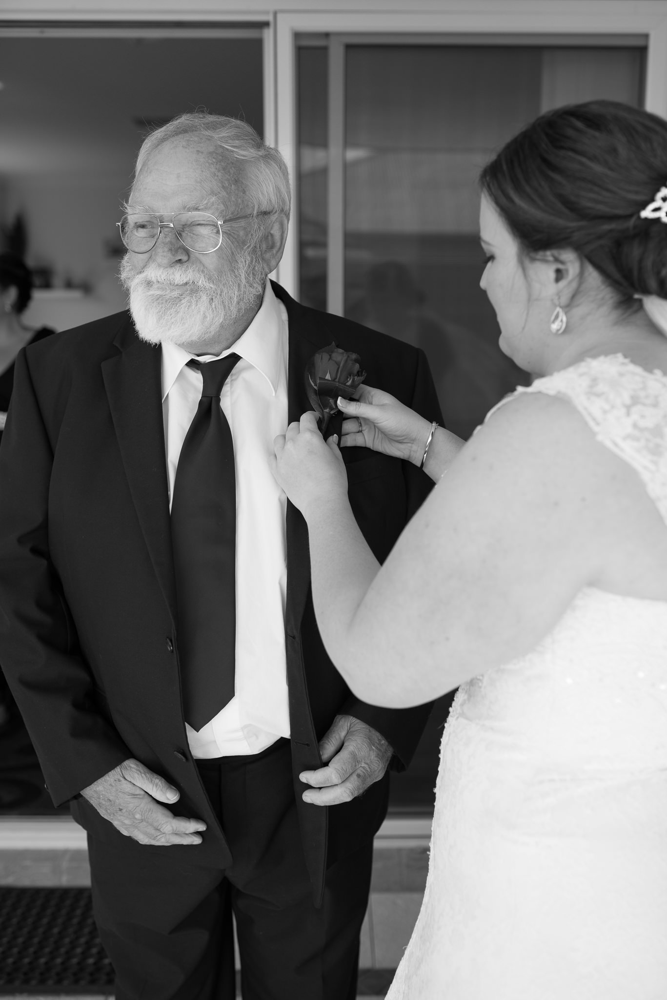 bride putting on her father's buttonhole