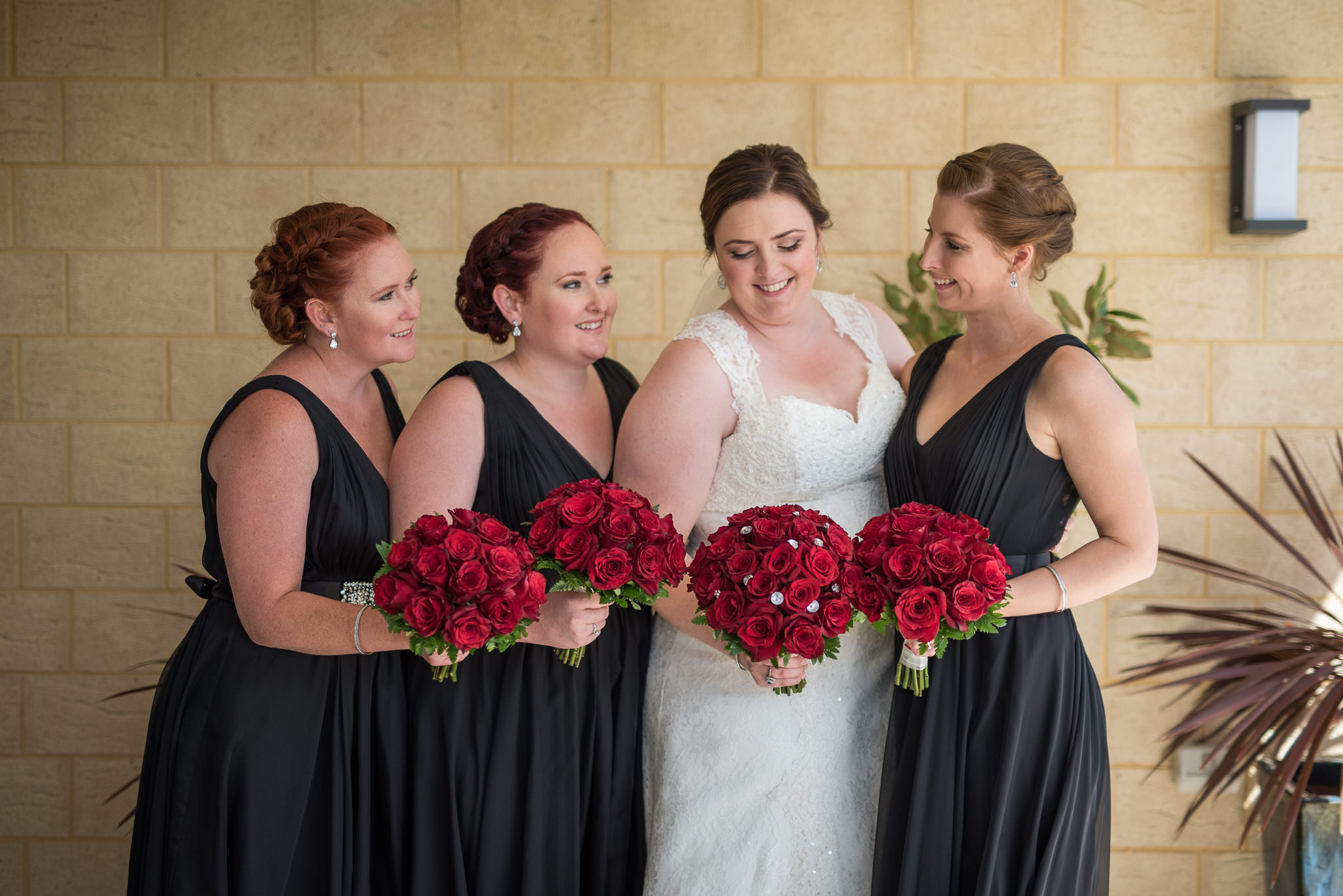 bride and bridesmaid portrait with red rose bouquet