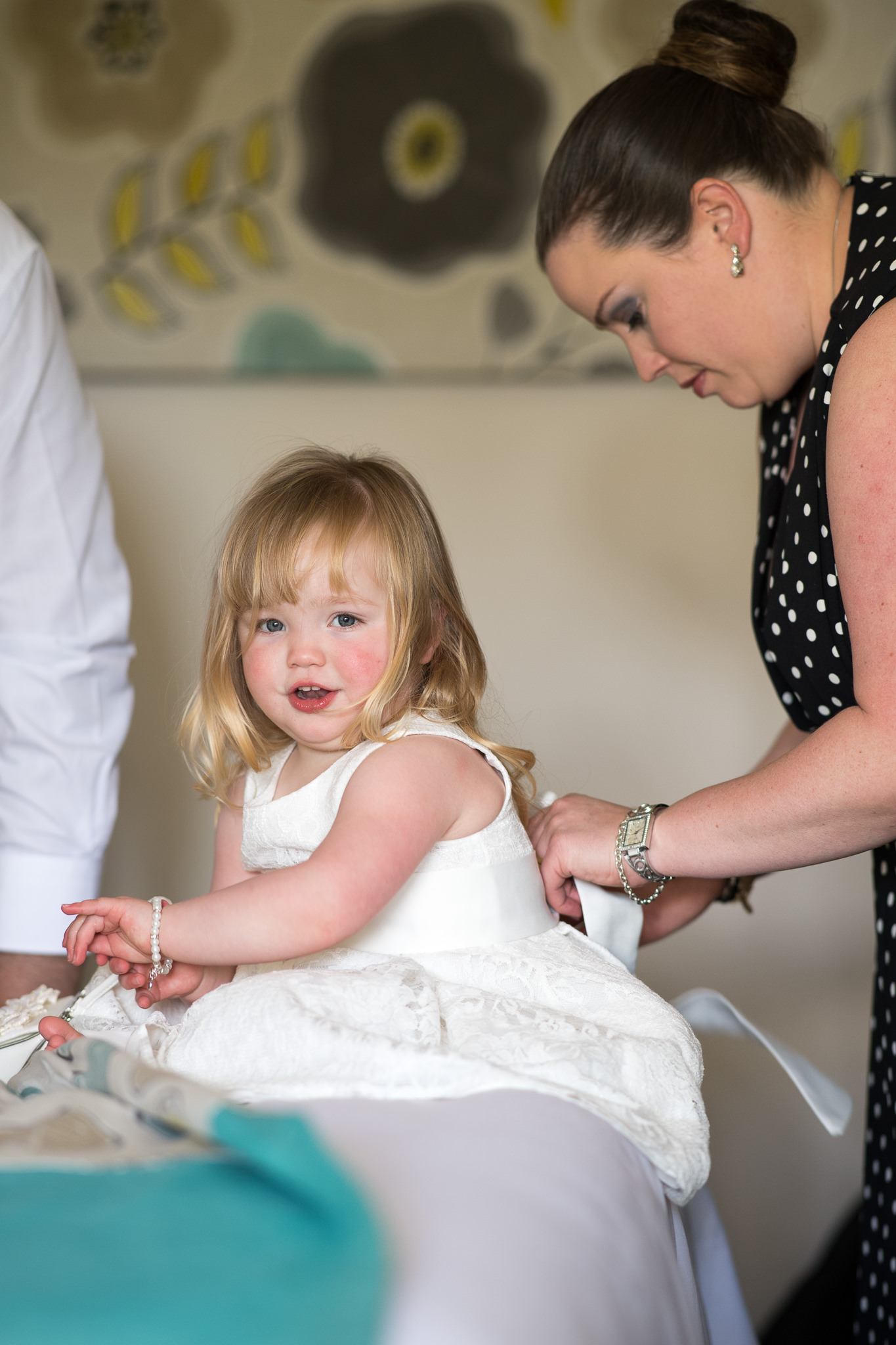 flower girl having her dress put on