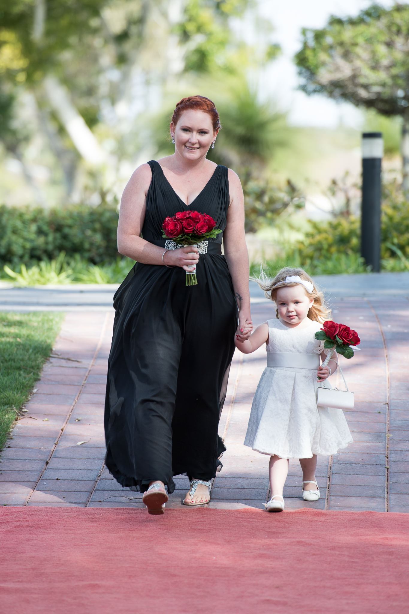 bridesmaid walks little flower girl down the aisle