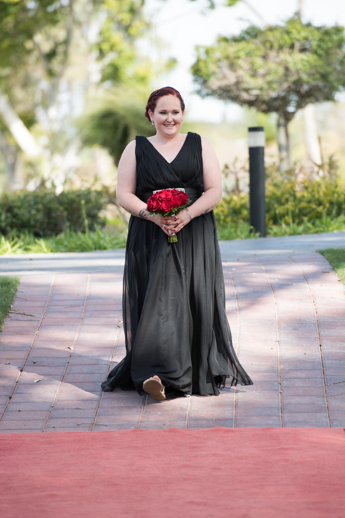 bridesmaid walks down the aisle in black dress