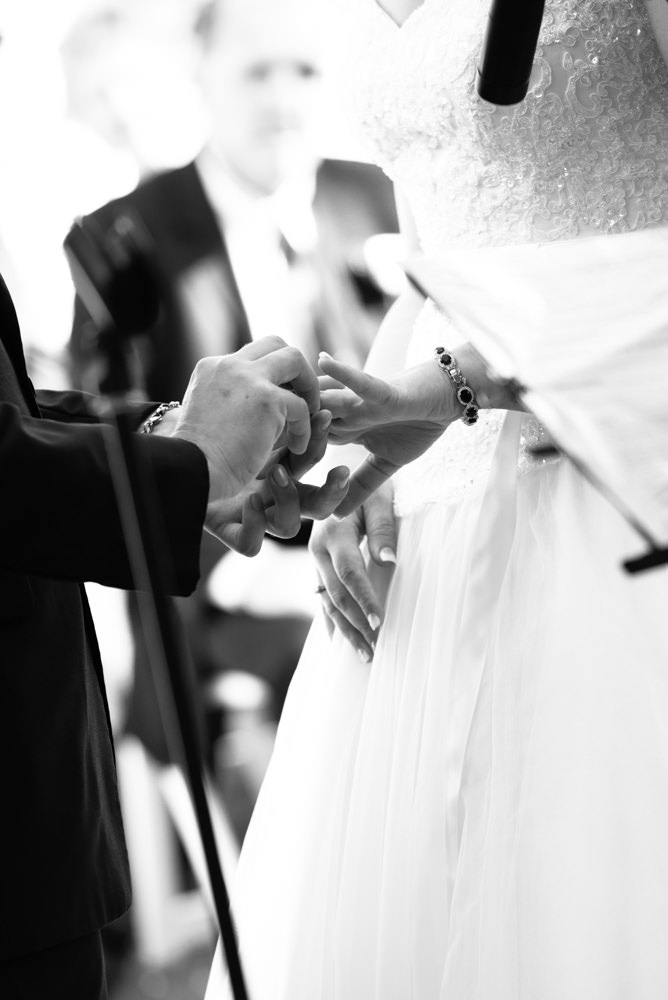 Groom puts ring on brides hand