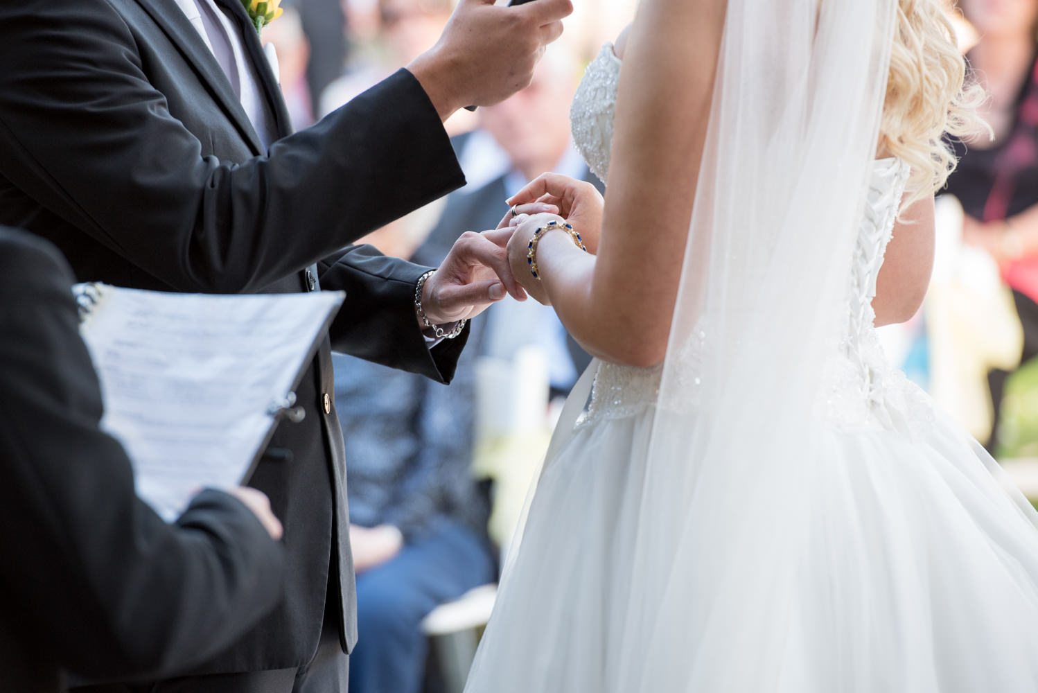 Bride puts ring on grooms hand