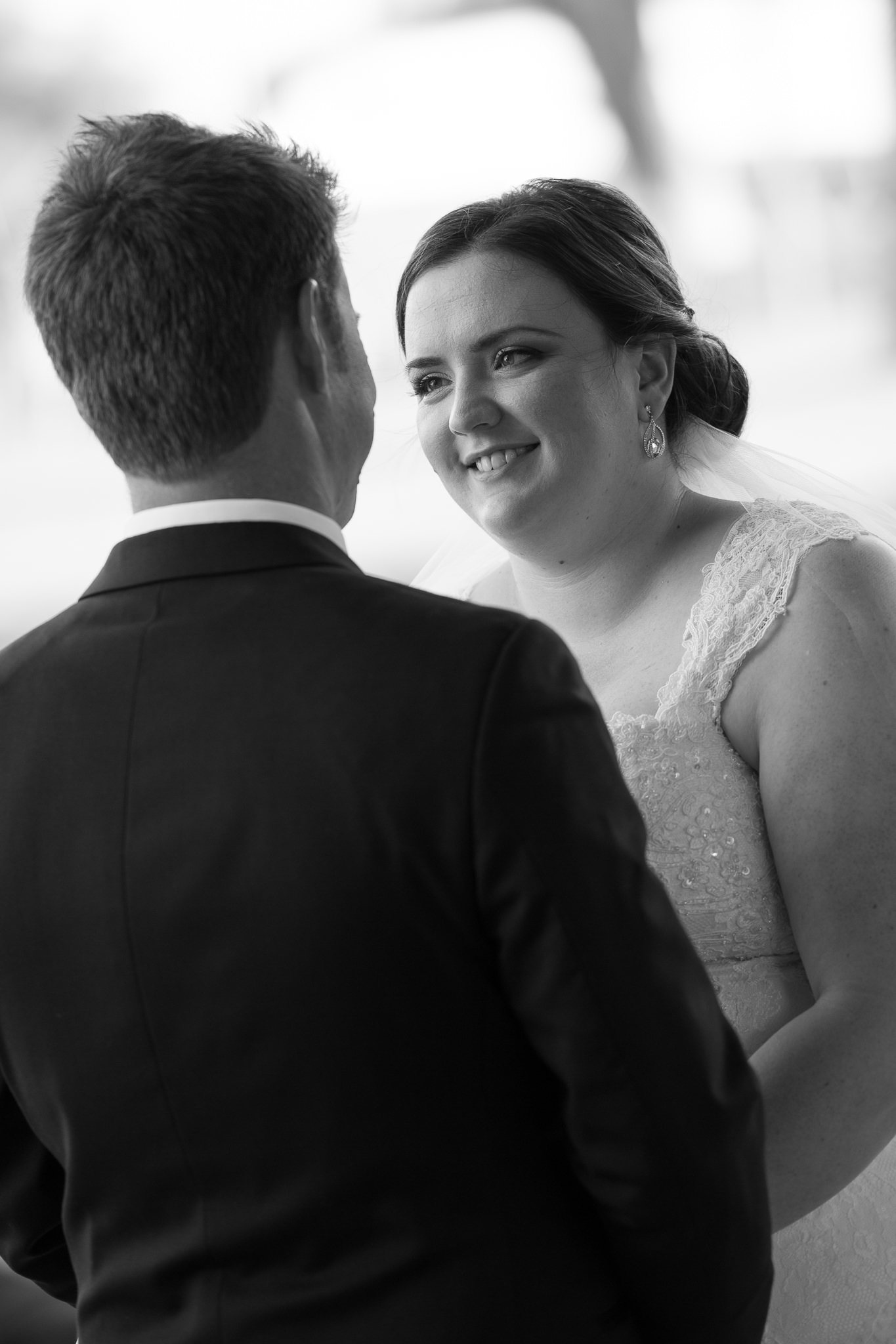 bride smiles at her groom in black and white