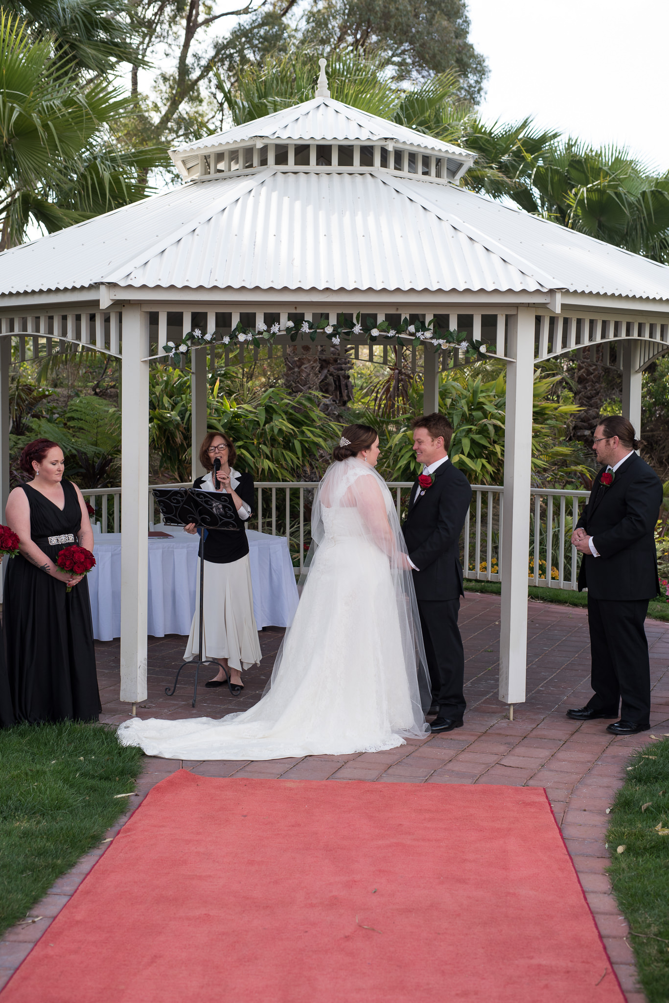 bride and groom holding hands during ceremony under the joondalup resort rotunda