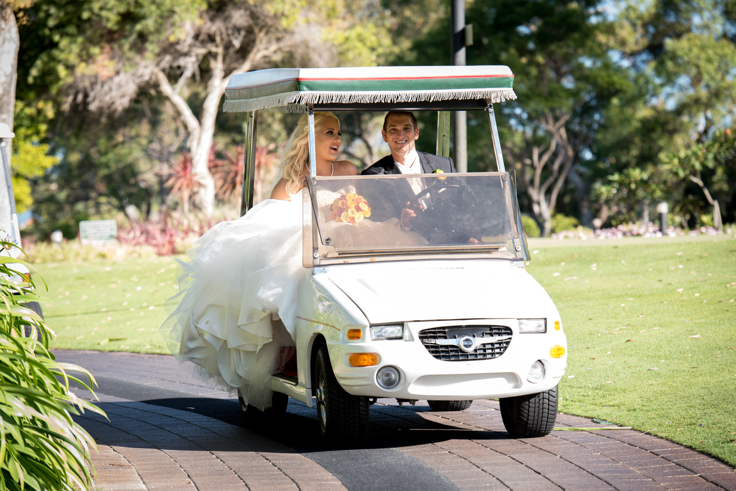 Bride and groom in golf cart