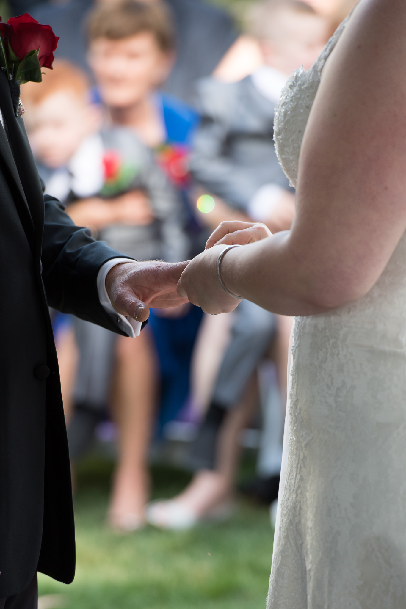 close up of bride placing ring on groom's finger