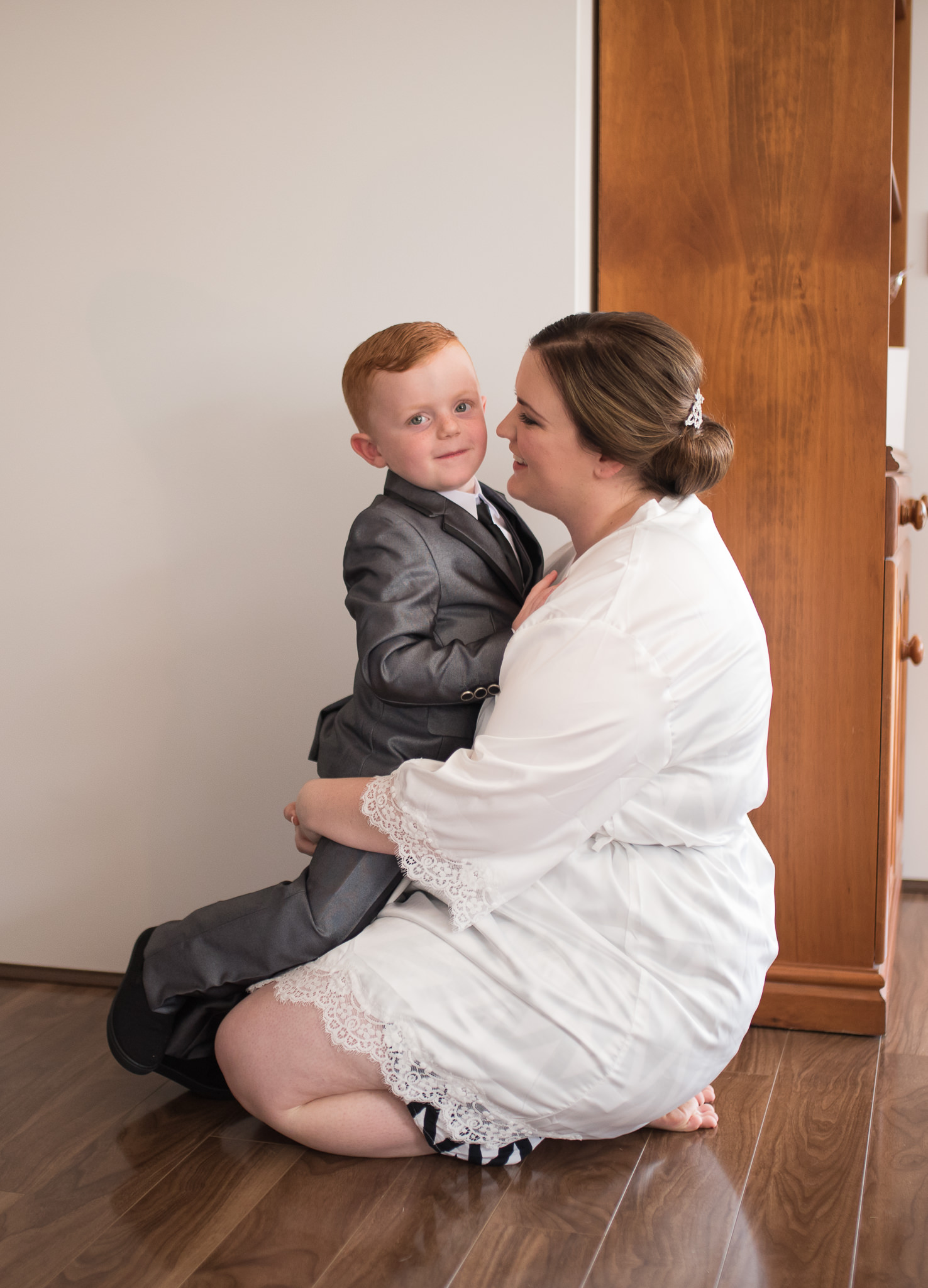 bride on her knees cuddling a page boy