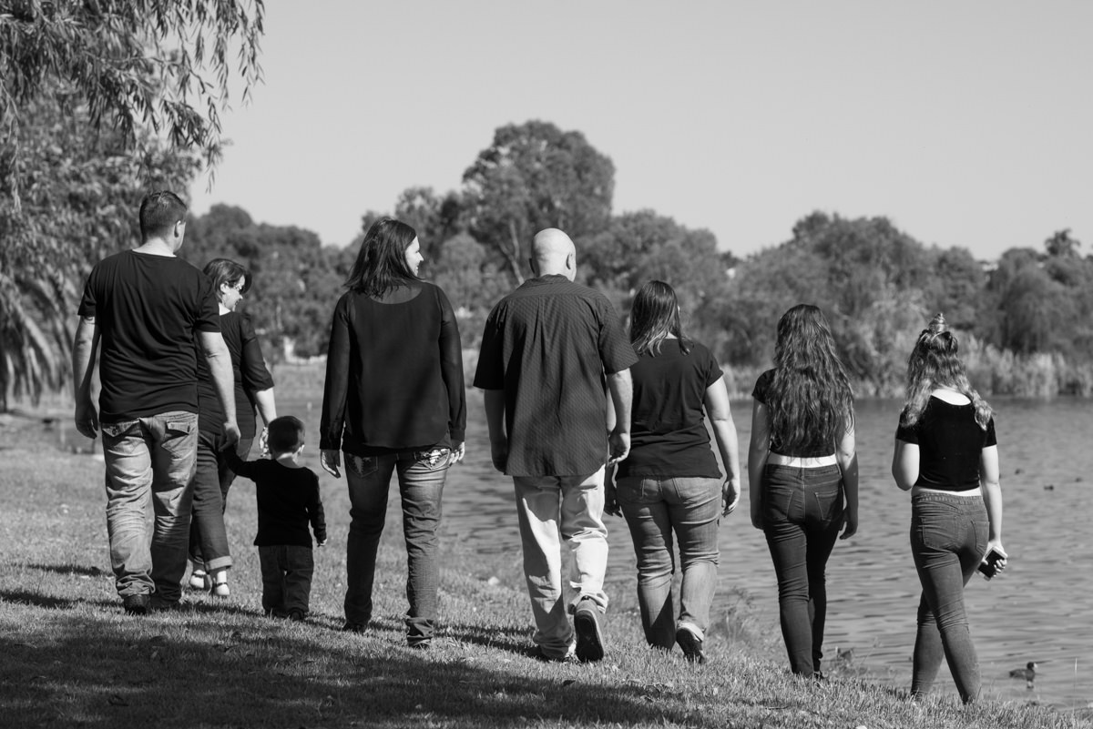 Black and white photo of family walking along the edge of Lake Monger