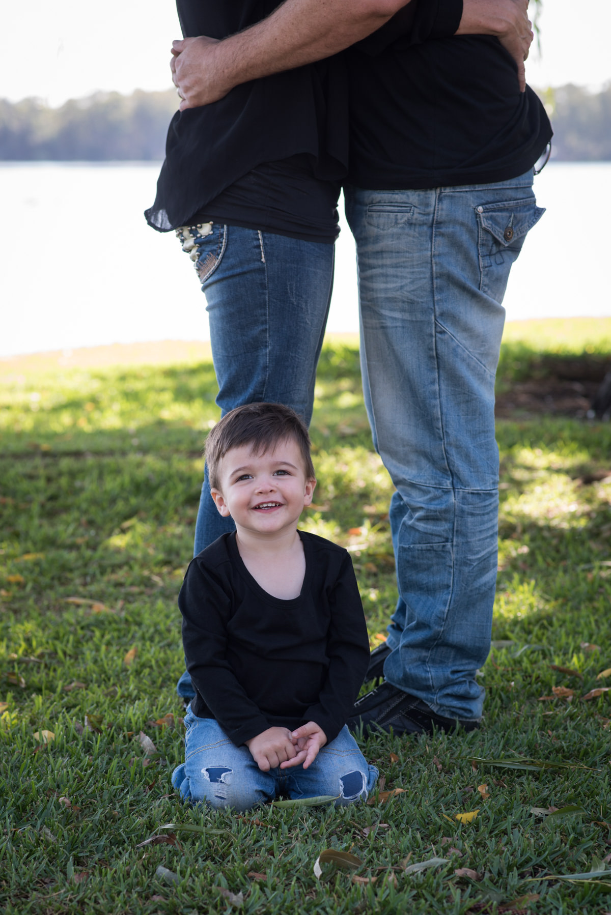 Portrait of a small boy next to his parents legs by Kruger Photography