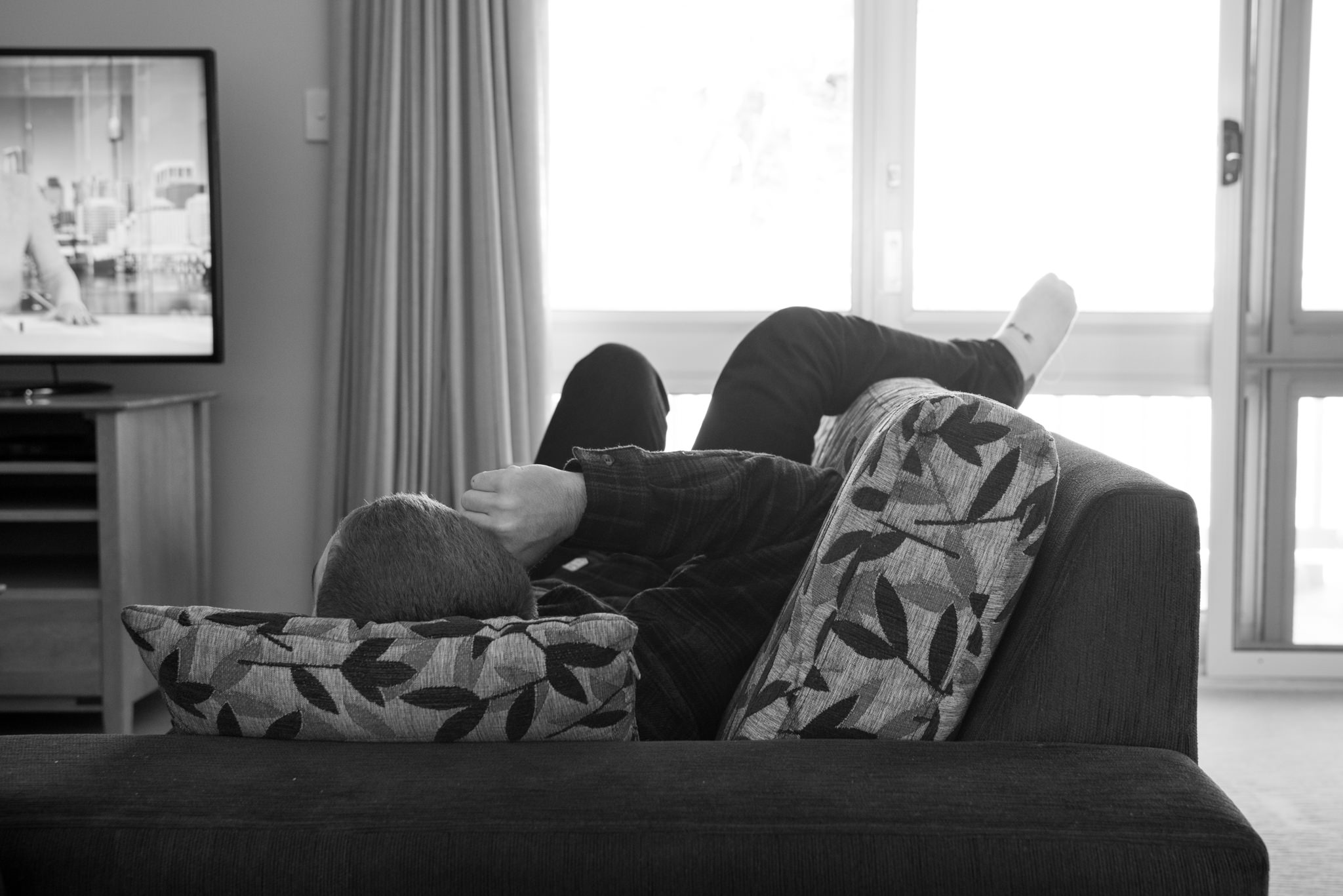 Best man relaxes on couch on the morning of the wedding watching TV