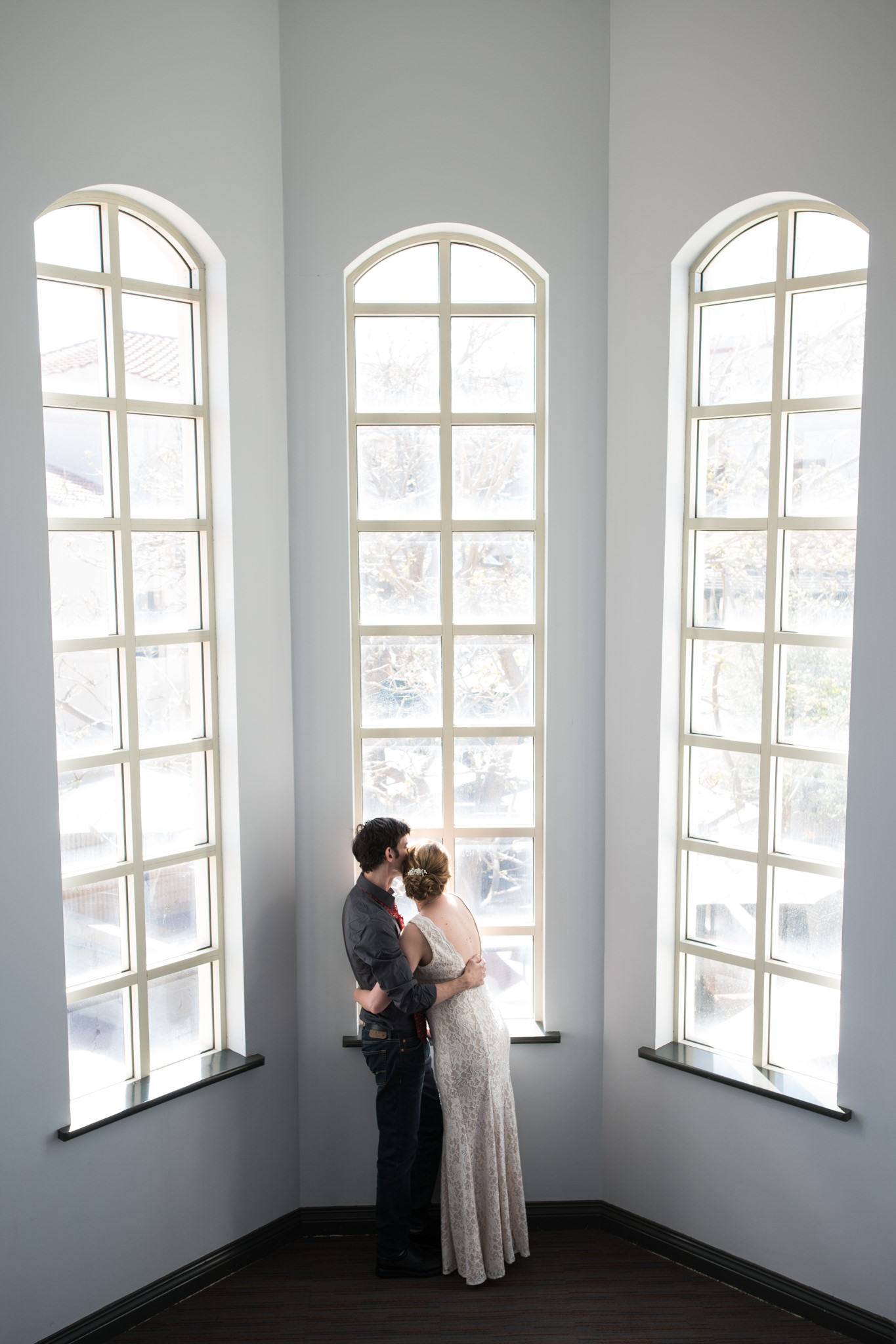 Soft pastel photo of bride and groom cuddling in Mindarie Marina windows