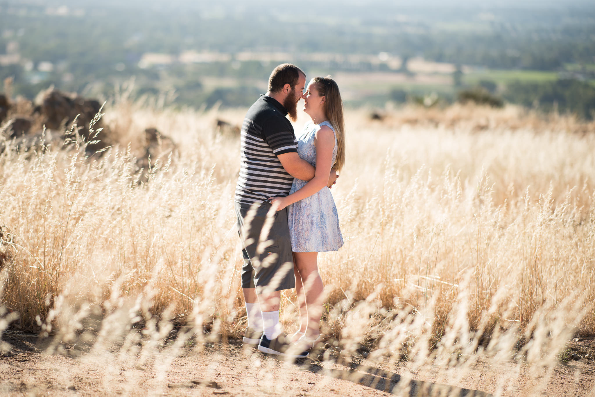 young boy and girl cuddling amongst dry reeds