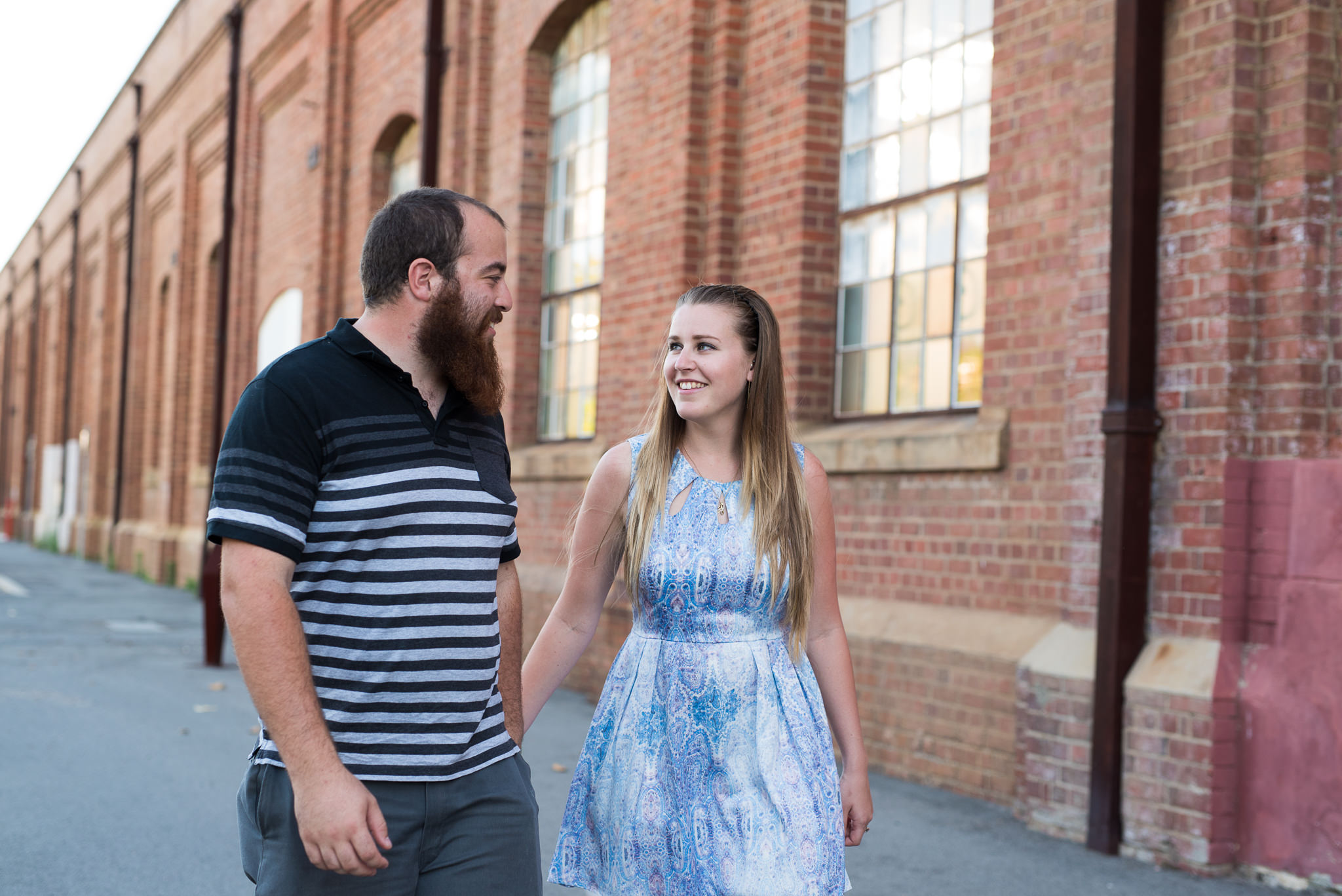 Boy with beard and girl walking in the laneways of Midland railway workshops