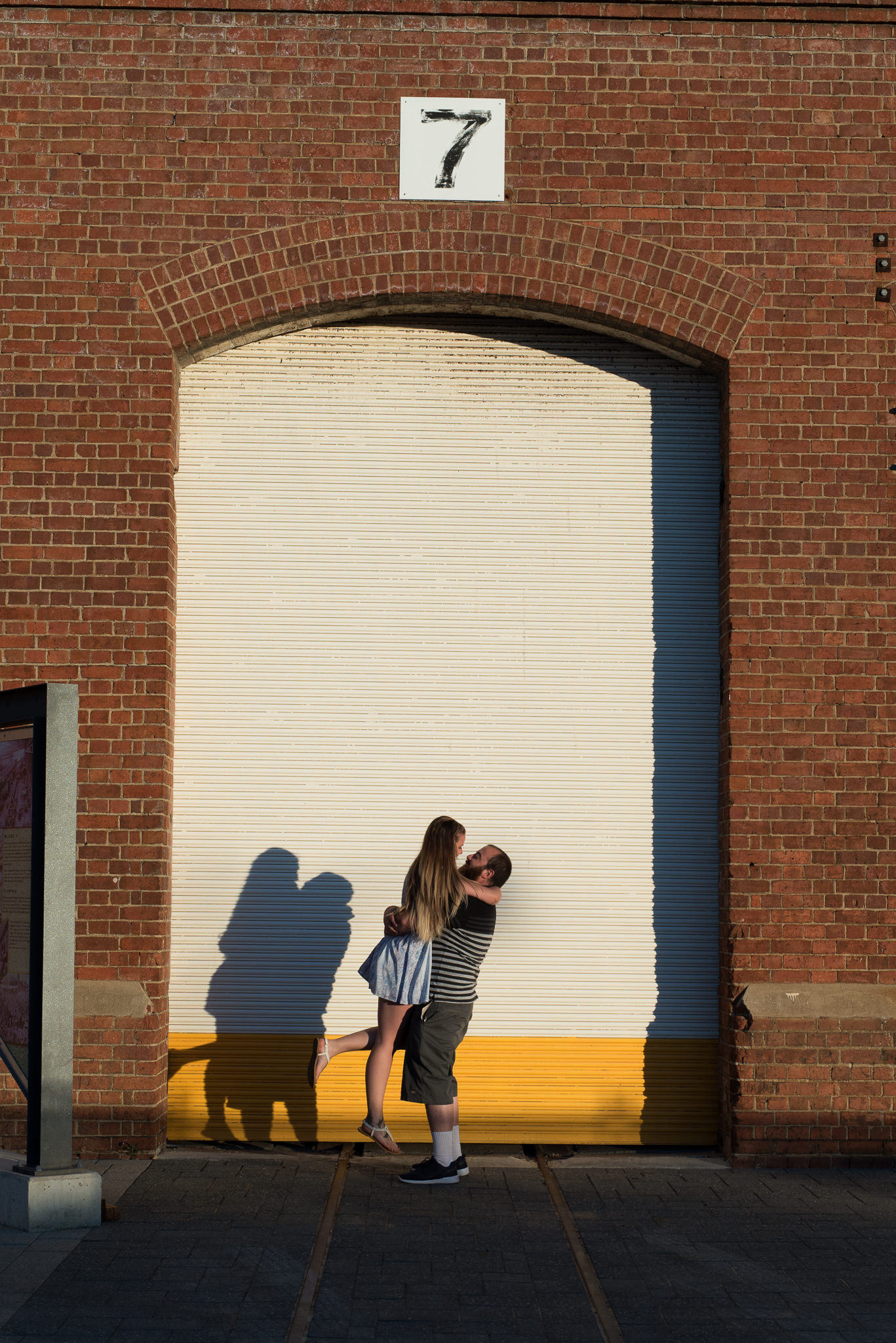 guy picking up his fiancee in front of shed doors at Midland Railway workshops