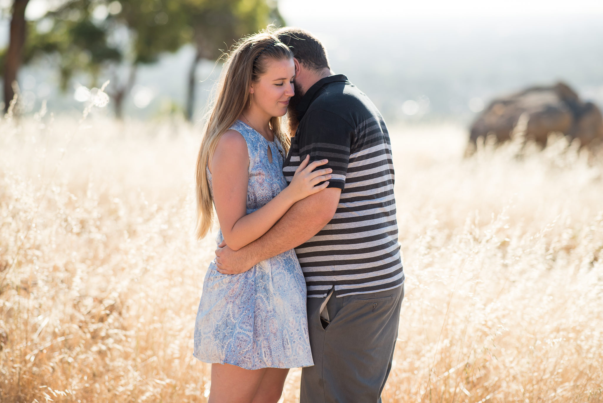 golden weeds surrounding a young engaged couple