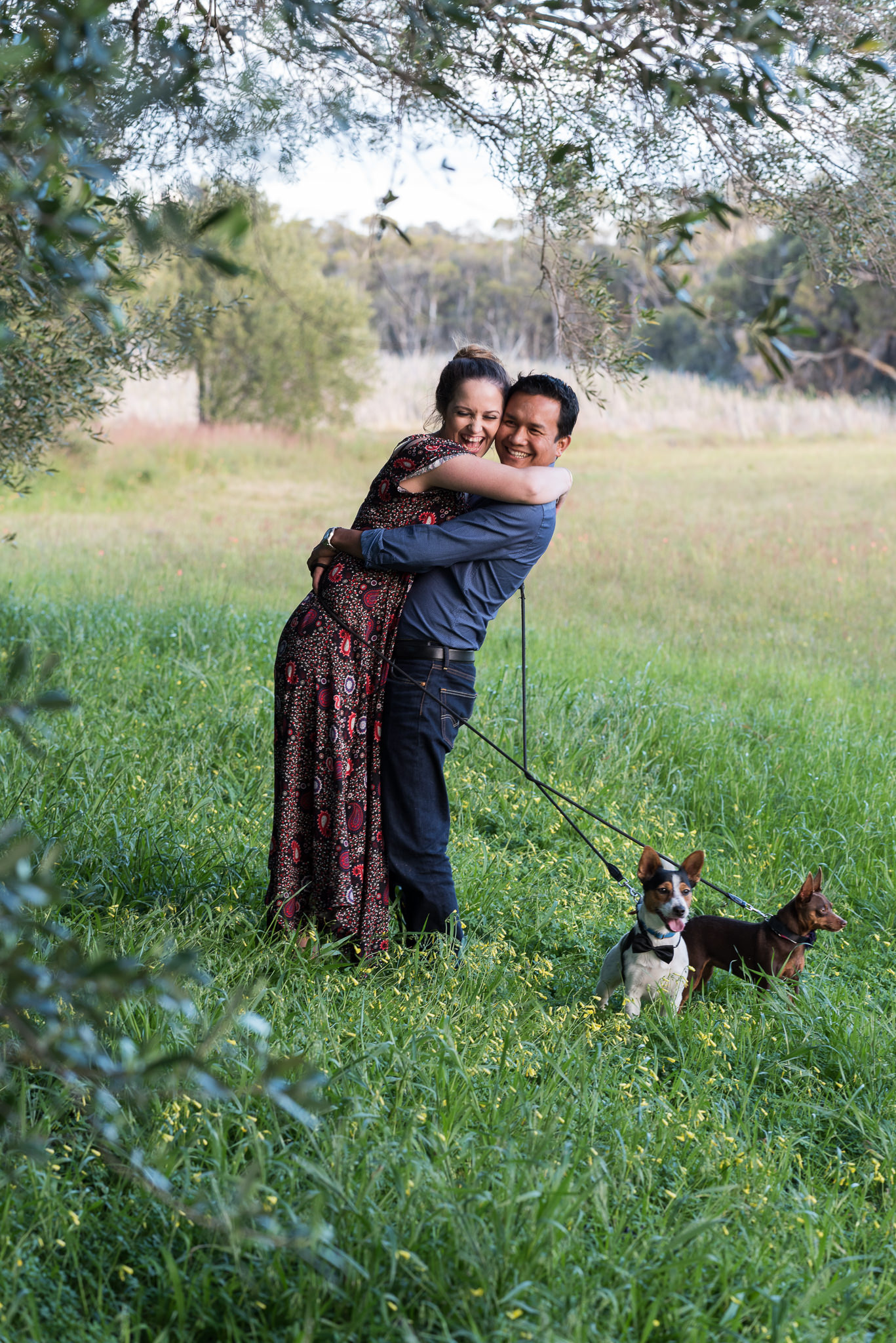 couple laughing and hugging in the long grass