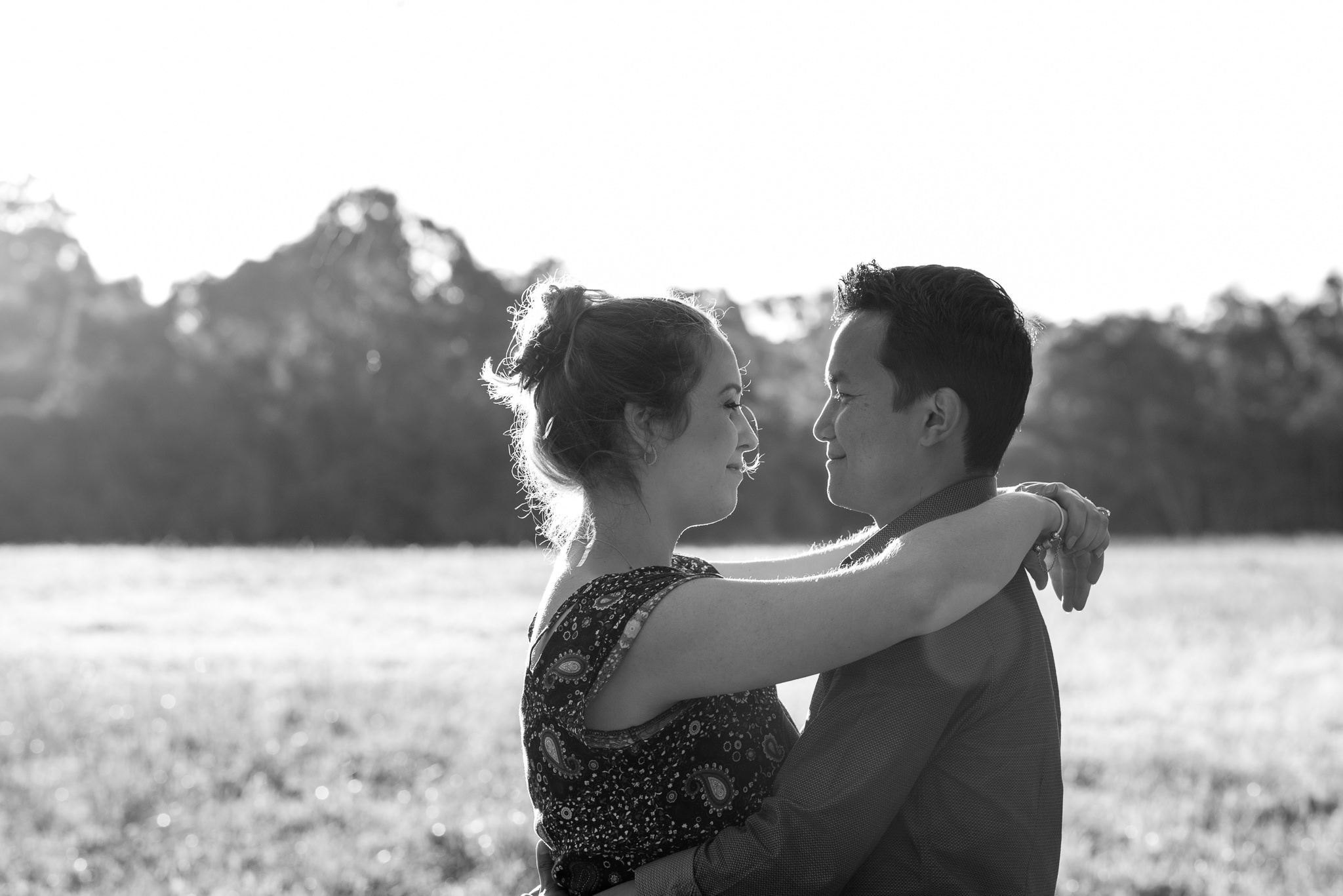 couple with arms draped over shoulder smiling at Perry's paddock