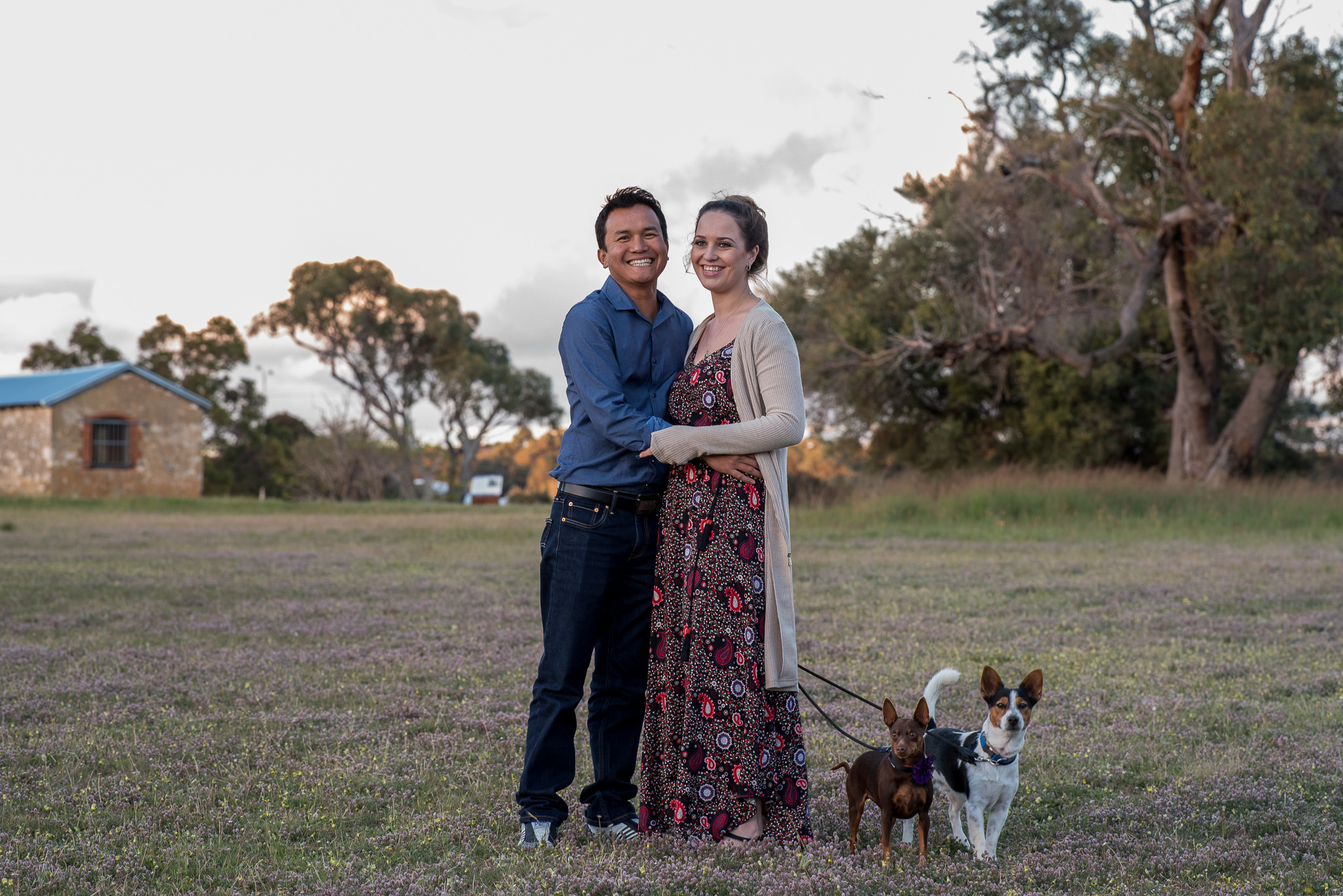 couple smiling with their two dogs