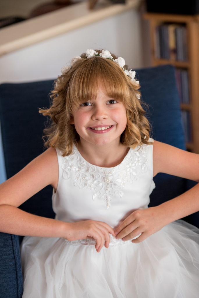 flower girl smiling at camera with flower crown