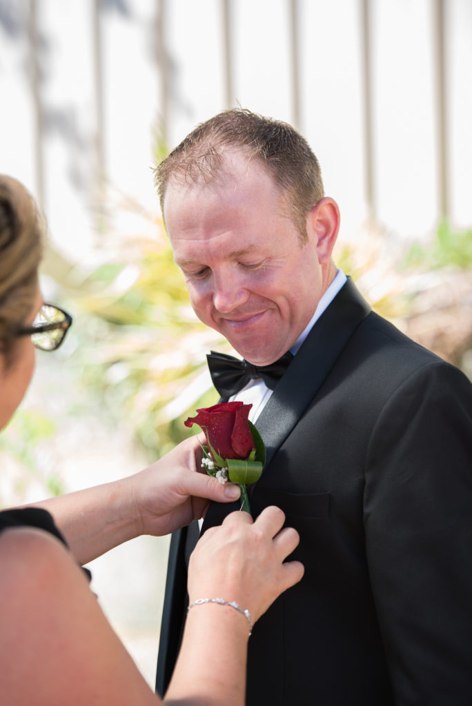 groom having his buttonhole put on