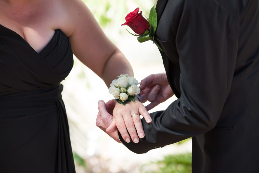 groom putting corsage on wrist