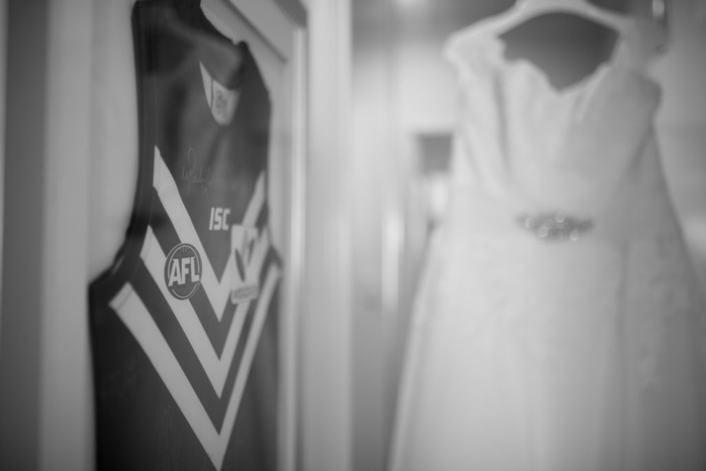 AFL shirt on wall next to wedding dress hanging