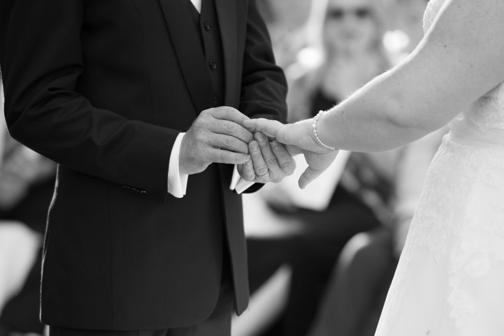 groom puts ring on her finger