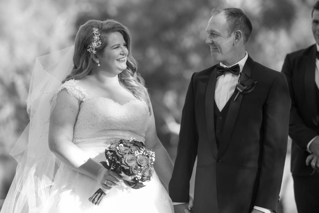 bride and groom smiling at each other