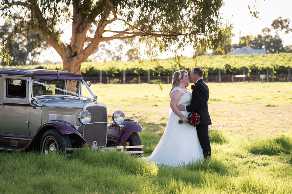 bride and groom with vintage wedding limo