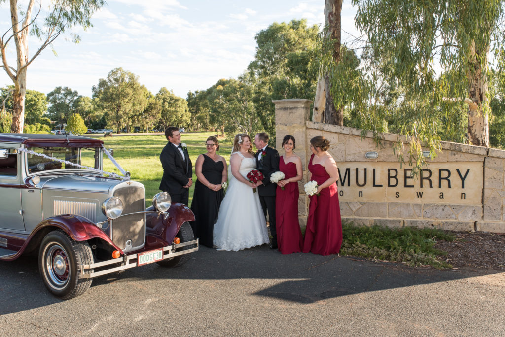 bridal party with wedding car at the entrance to Mulberry on Swan