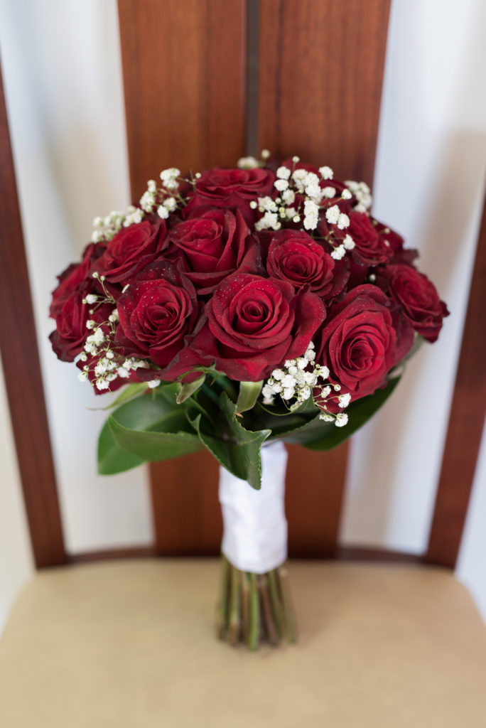 close up of bride's wedding bouquet of red roses