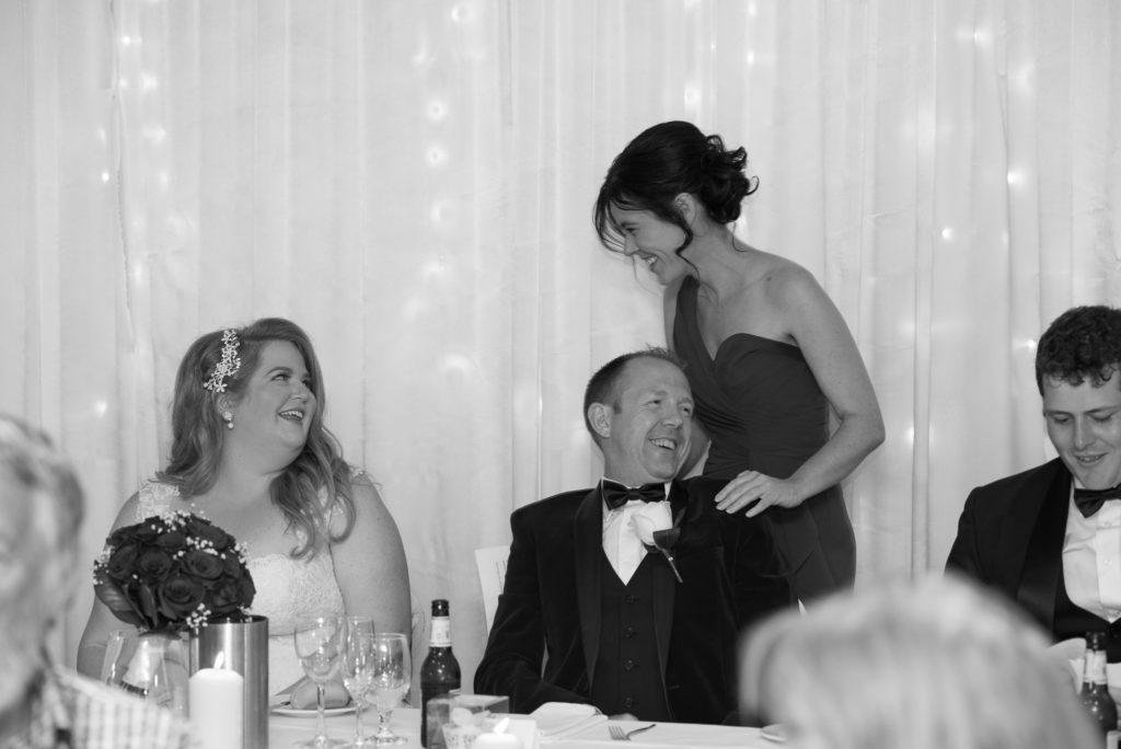 Bride laughing at her bridesmaid's speech