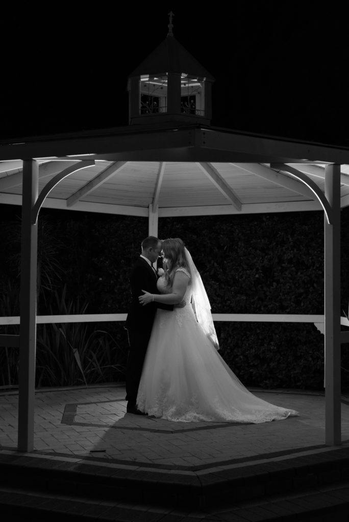 bride and groom in rotunda pressing foreheads in black and white