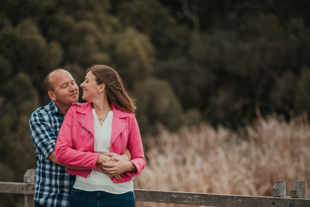 engaged couple looking at each other in the bush