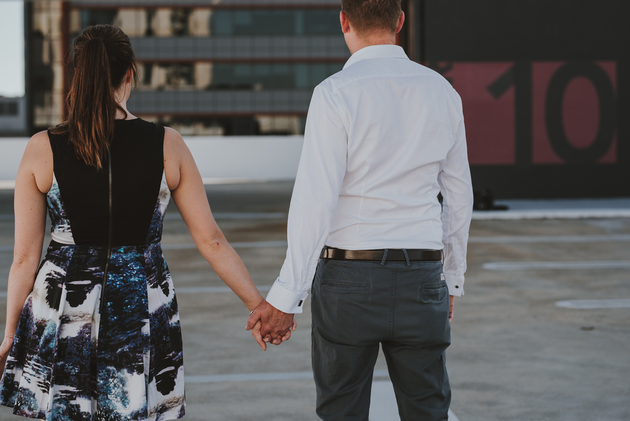 Boy and girl on level 10 of carpark rooftop for engagement photos